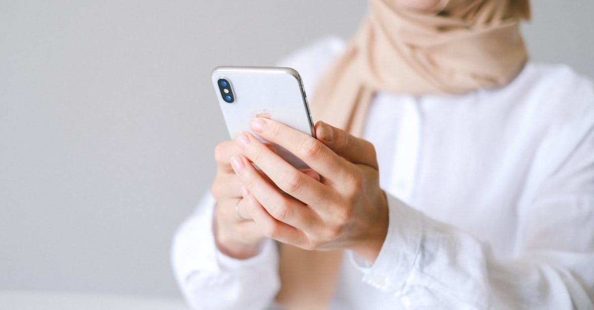 How can I most affordably use my iPhone in the UK during a long-term study abroad period? [closed] - Photo of Person using White Smartphone
