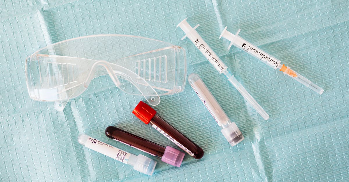 How can I protect myself sending a Photo of a passport to a private COVID test provider? - Top view of empty and full of blood vials and plastic syringes and eyeglasses  placed on medical diaper