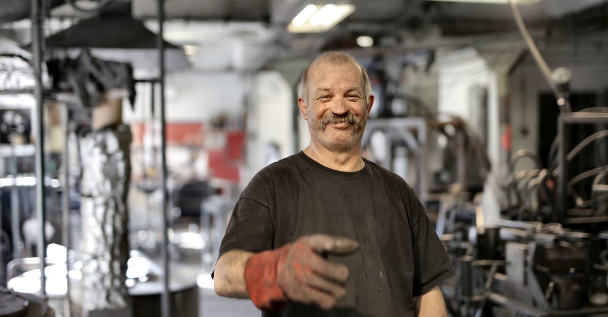 How can I repair my old and expired passport? - Cheerful senior white hair craftsman in heavy duty gloves laughing in workshop while looking at camera How can I repair my old and expired passport? - Cheerful senior white hair craftsman in heavy duty gloves laughing in workshop while looking at camera
