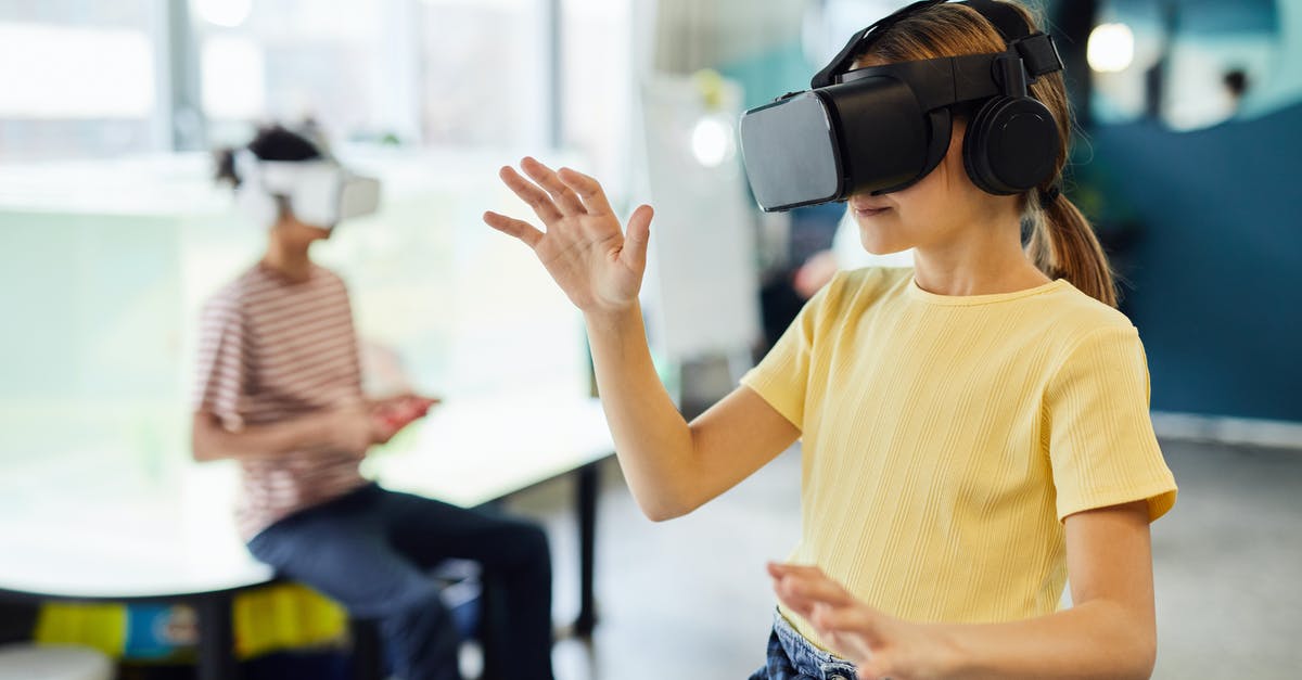How can I use my new Miles & More membership? - Young female in VR glasses standing in light room and testing new device How can I use my new Miles & More membership? - Young female in VR glasses standing in light room and testing new device