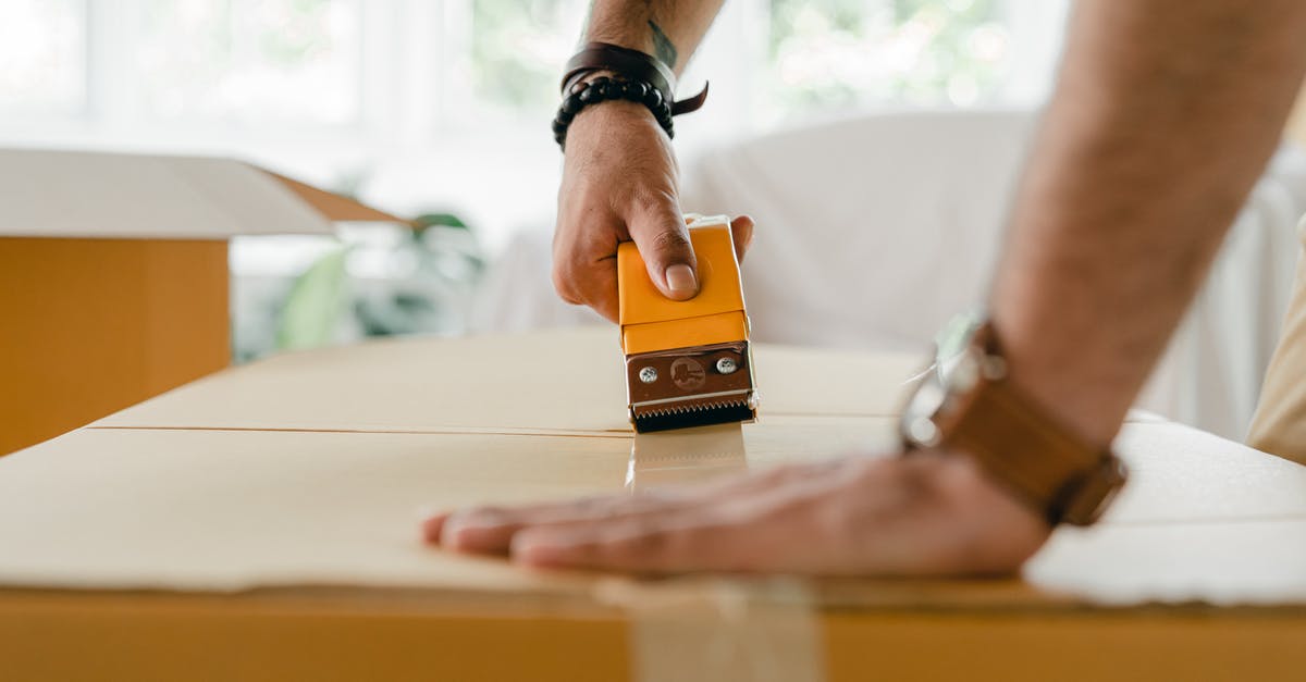 How can I use my new Miles & More membership? - Crop man packing carton box with scotch tape dispenser How can I use my new Miles & More membership? - Crop man packing carton box with scotch tape dispenser