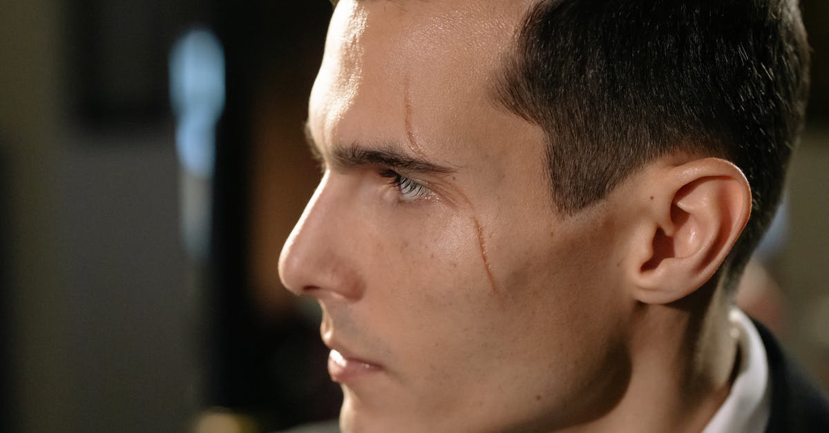 How can non-Caucasians avoid suspicious looks when traveling in the West? - Close-Up Photo of Man with Scar on his Face