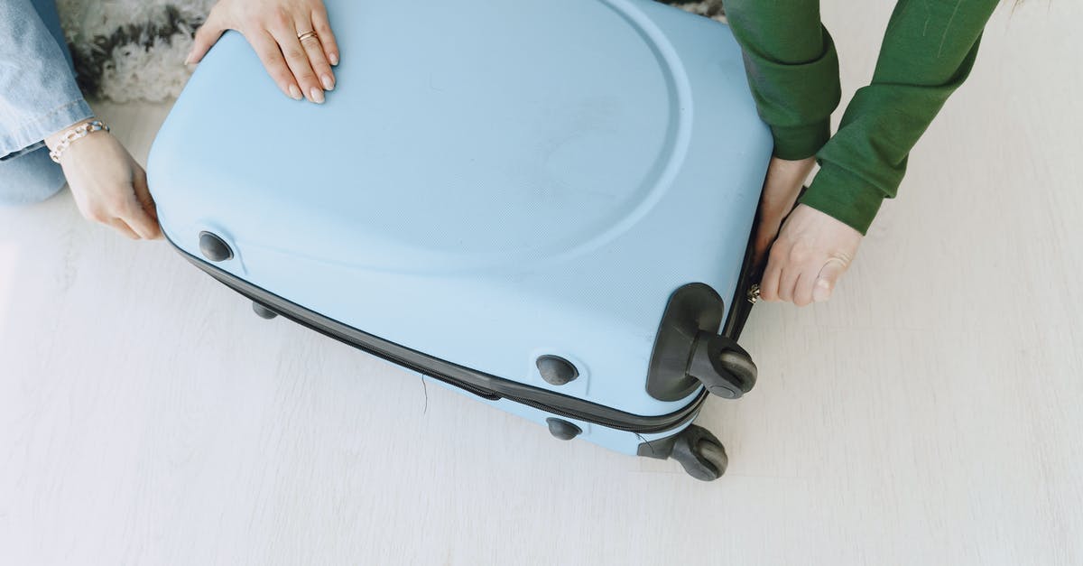 How do I arrive at the total individual expenses I had during a trip with my friend? [closed] - Unrecognizable female friends in casual clothes sitting on floor with fluffy carpet and opening suitcase together while preparing for journey and adventure