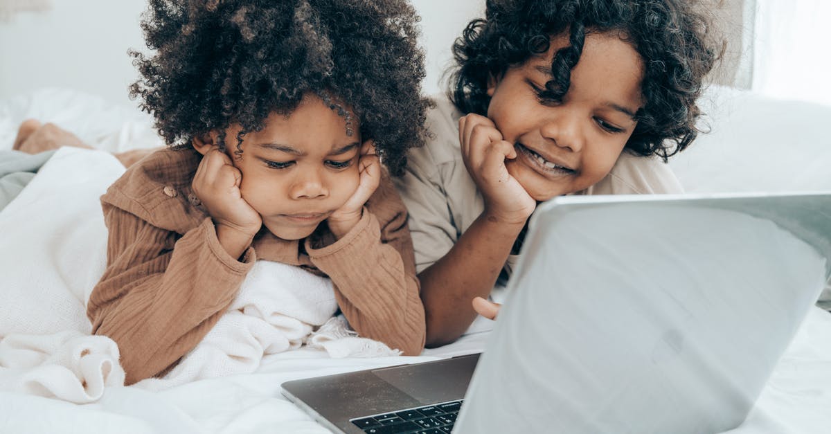 How do I identify an airport’s official free Wi-Fi network? - Disappointed and smiley black brothers in pajamas lying on bed in daytime while using laptop surfing Internet together