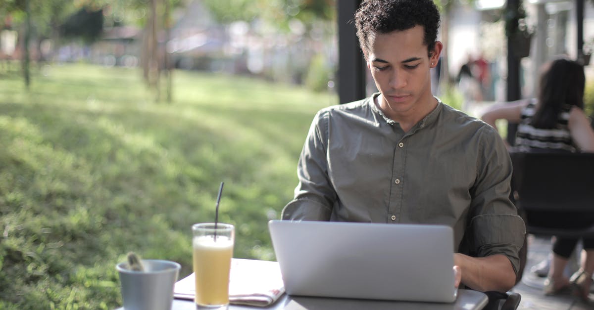 How do I search for upscale self-service restaurants? - Focused black male freelancer using laptop in street cafe How do I search for upscale self-service restaurants? - Focused black male freelancer using laptop in street cafe