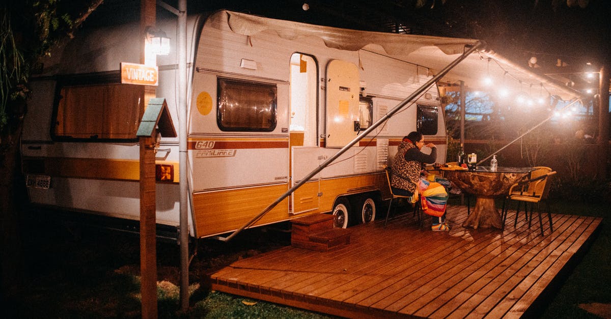 How do I transport a foldable lawn chair via Airline baggage? - Side view of female tourist at table with alcoholic drink against camping trailer with shiny lamps at night How do I transport a foldable lawn chair via Airline baggage? - Side view of female tourist at table with alcoholic drink against camping trailer with shiny lamps at night