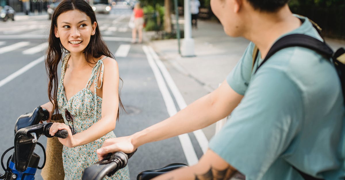 How do US intercity bus companies relate to each other? - Smiling couple in casual clothes standing with bicycles on asphalt road in city in sunny day How do US intercity bus companies relate to each other? - Smiling couple in casual clothes standing with bicycles on asphalt road in city in sunny day