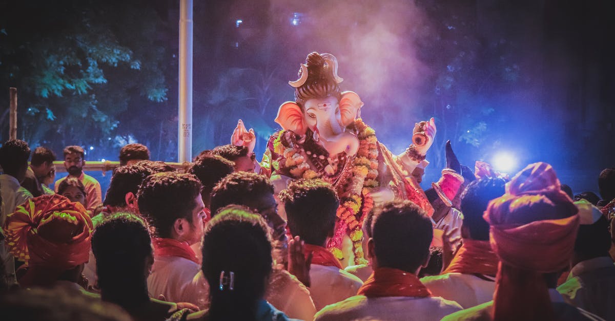 How do western people perceive Indians worshipping cows in Hindu temples? [closed] - Photo of People Standing in Front of Ganesha Statue