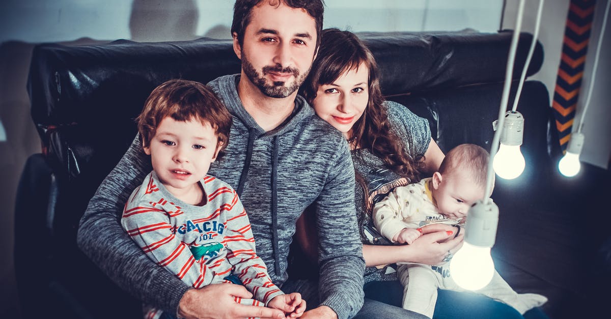 How do you seat a baby securely on a coach transfer? - Man and Woman Carrying Babies While Sitting on Chair How do you seat a baby securely on a coach transfer? - Man and Woman Carrying Babies While Sitting on Chair