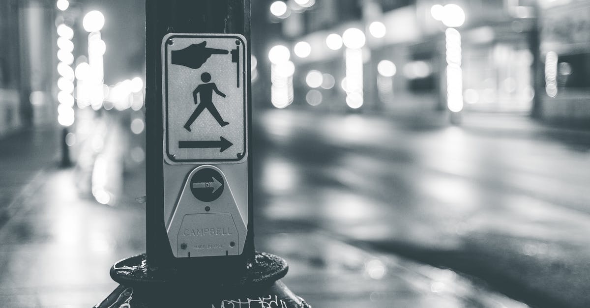 How do you use Berlin crosswalk signal boxes? - Pedestrian crosswalk button placed near roadway in city in evening time How do you use Berlin crosswalk signal boxes? - Pedestrian crosswalk button placed near roadway in city in evening time