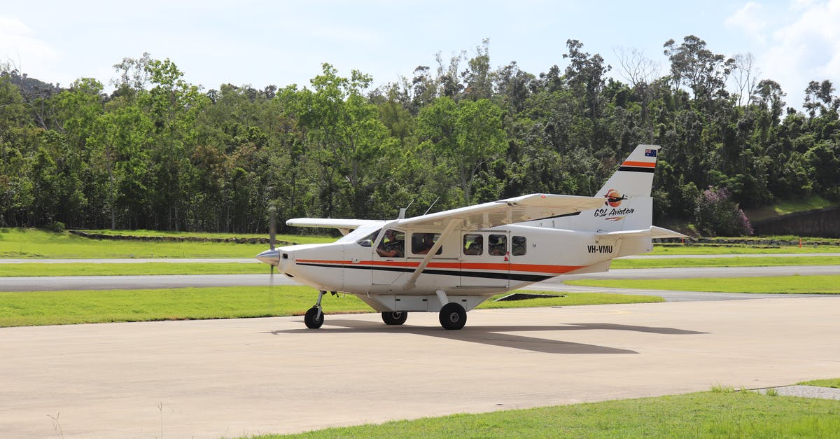 How does a hurricane making landfall between departure and destination affect air travel? - Modern small turboprop plane landing on airfield surrounded with lush green trees in tropical country on sunny day