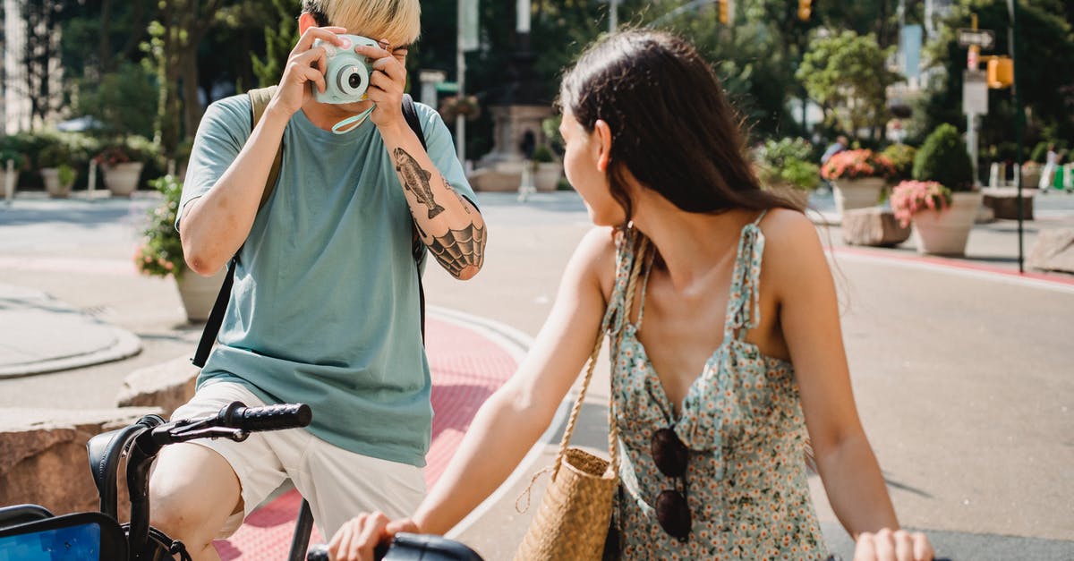 How does Berlin Transport Validation Stamp mark current date and/or expiry date? [duplicate] - Anonymous male with instant camera taking picture of unrecognizable girlfriend on bicycle while standing on pavement on street in city