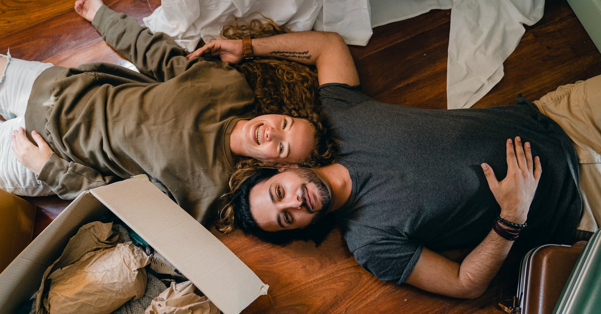 How does the new landlord duty affect visitors to the UK? - From above of young smiling diverse couple in casual clothing relaxing on floor near carton boxes while unpacking belongings in new contemporary apartment How does the new landlord duty affect visitors to the UK? - From above of young smiling diverse couple in casual clothing relaxing on floor near carton boxes while unpacking belongings in new contemporary apartment