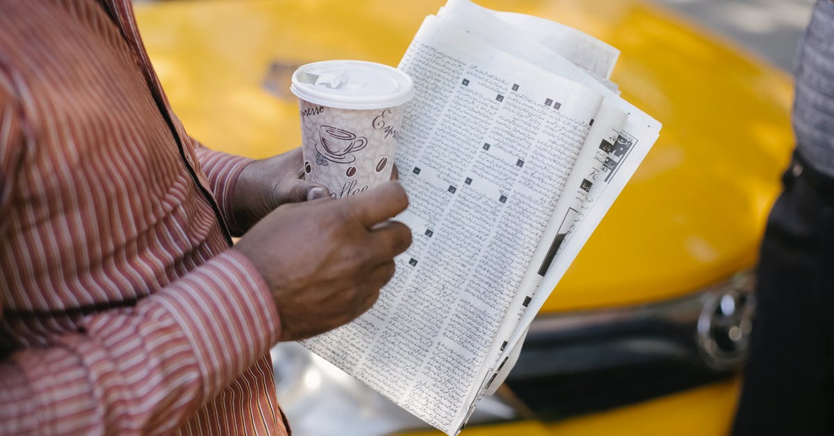How far do taxis from Incheon Airport go? - From above side view of crop anonymous ethnic male cab driver with coffee to go and newspaper talking to coworker on street How far do taxis from Incheon Airport go? - From above side view of crop anonymous ethnic male cab driver with coffee to go and newspaper talking to coworker on street