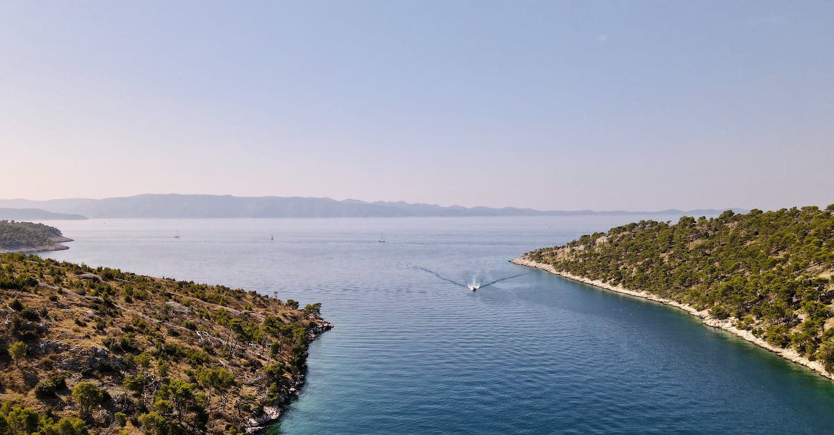 How fast can one expect to travel in an ocean-going sailboat? - Motorboat on sea between greenery islands under sky How fast can one expect to travel in an ocean-going sailboat? - Motorboat on sea between greenery islands under sky