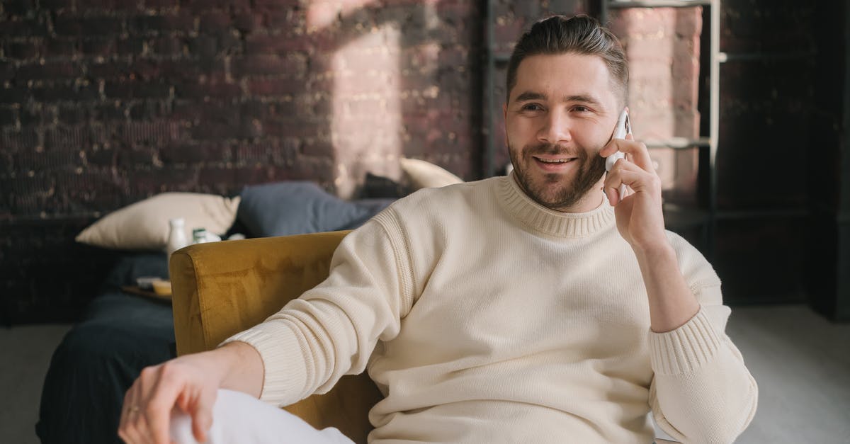 How fast is mobile internet in Malaysia? - Man in White Sweater Sitting on Brown Chair
