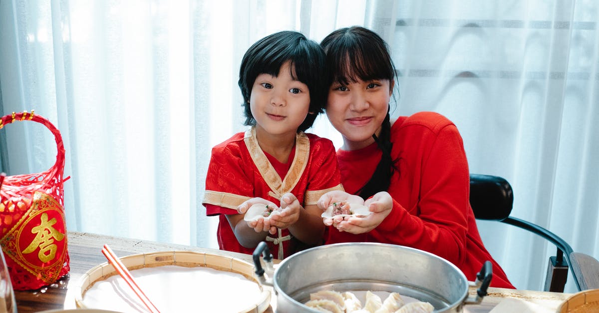 How is the renewing process like for an expired Chinese residence permit on expired passport? [closed] - Happy Asian teenage girl with dark hair cuddling with little brother and demonstrating traditional jiaozi dumplings during lunch preparation in kitchen