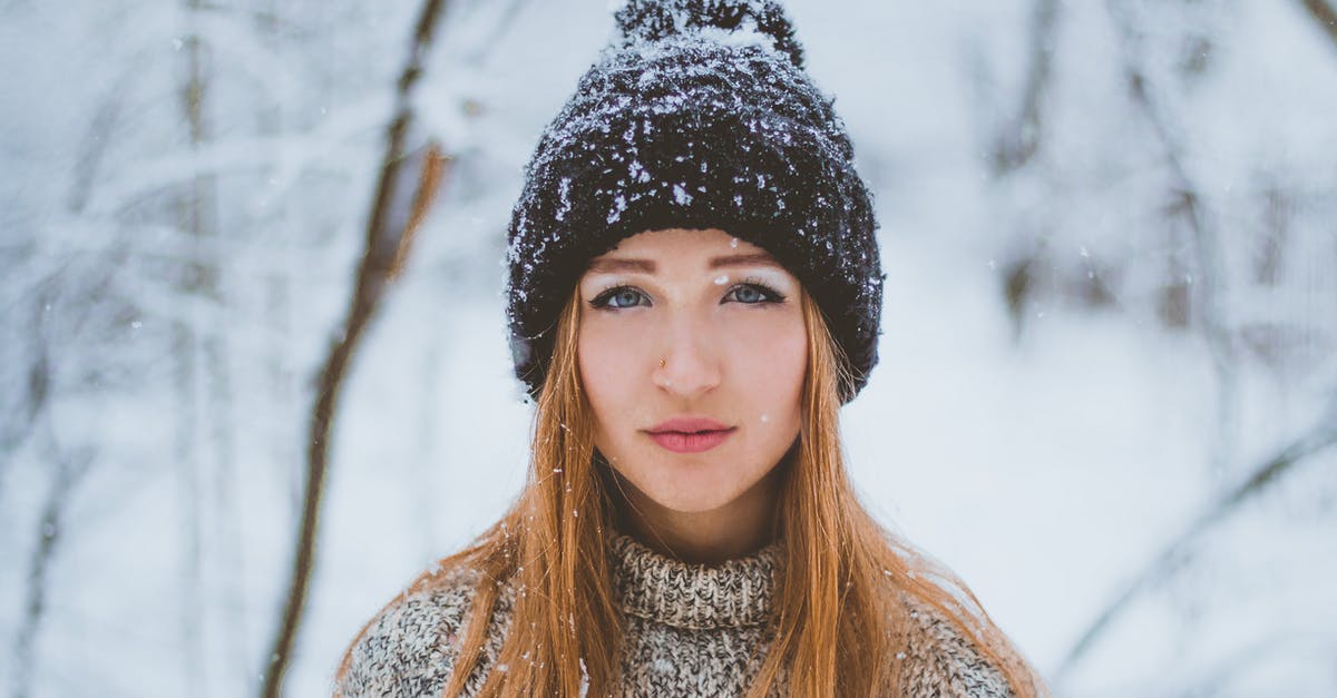 How long can I park in the blue zone in Switzerland? - Woman in warm knitted sweater and hat standing in winter forest How long can I park in the blue zone in Switzerland? - Woman in warm knitted sweater and hat standing in winter forest