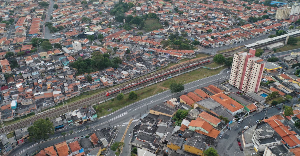How long can you stay on the Caledonian sleeper train once it has arrived? - Drone view of tall buildings and cottages near road and long railway in populated province How long can you stay on the Caledonian sleeper train once it has arrived? - Drone view of tall buildings and cottages near road and long railway in populated province