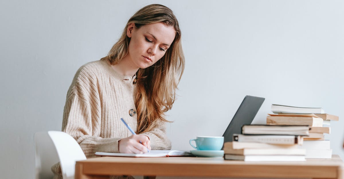 How long does it take for a Kuwait work visa to be renewed? [closed] - Concentrated female taking notes in planner near heap of many books and cup of strong coffee on white background