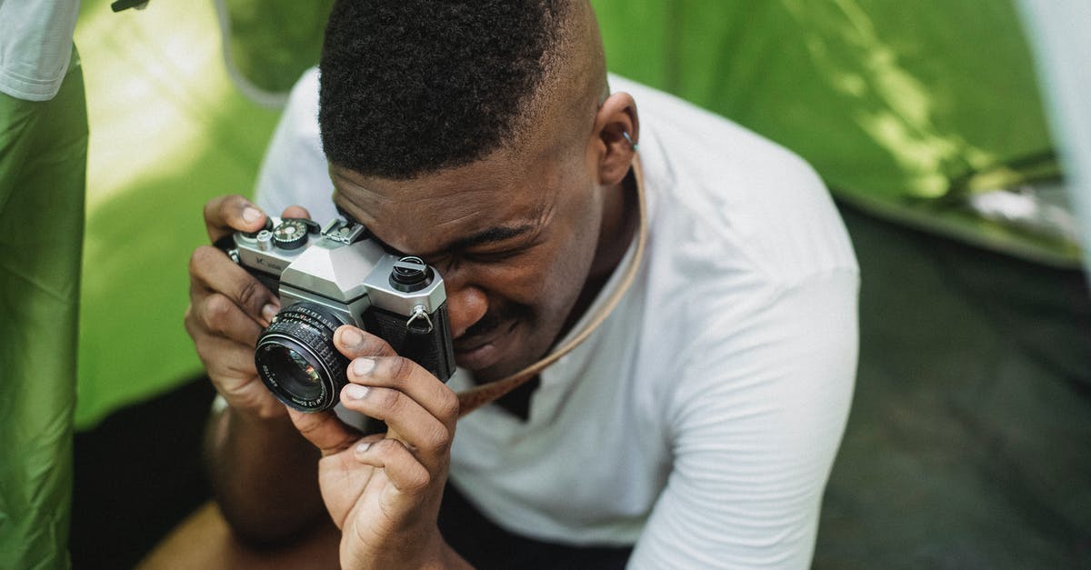 How long would it take to hike from Hamar to Lillehammer? - Black male hiker photographing on retro photo camera How long would it take to hike from Hamar to Lillehammer? - Black male hiker photographing on retro photo camera