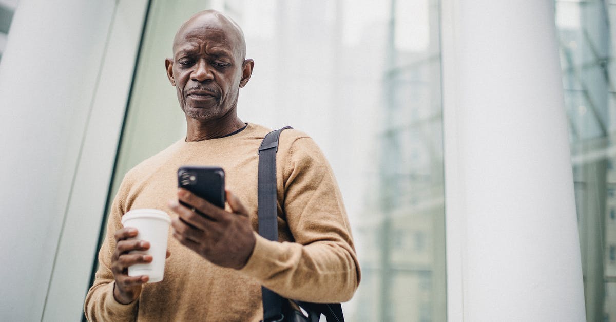 How manageable are <15 min connection times in Frankfurt Hbf? - Focused mature black man chatting on smartphone during coffee break on street How manageable are <15 min connection times in Frankfurt Hbf? - Focused mature black man chatting on smartphone during coffee break on street