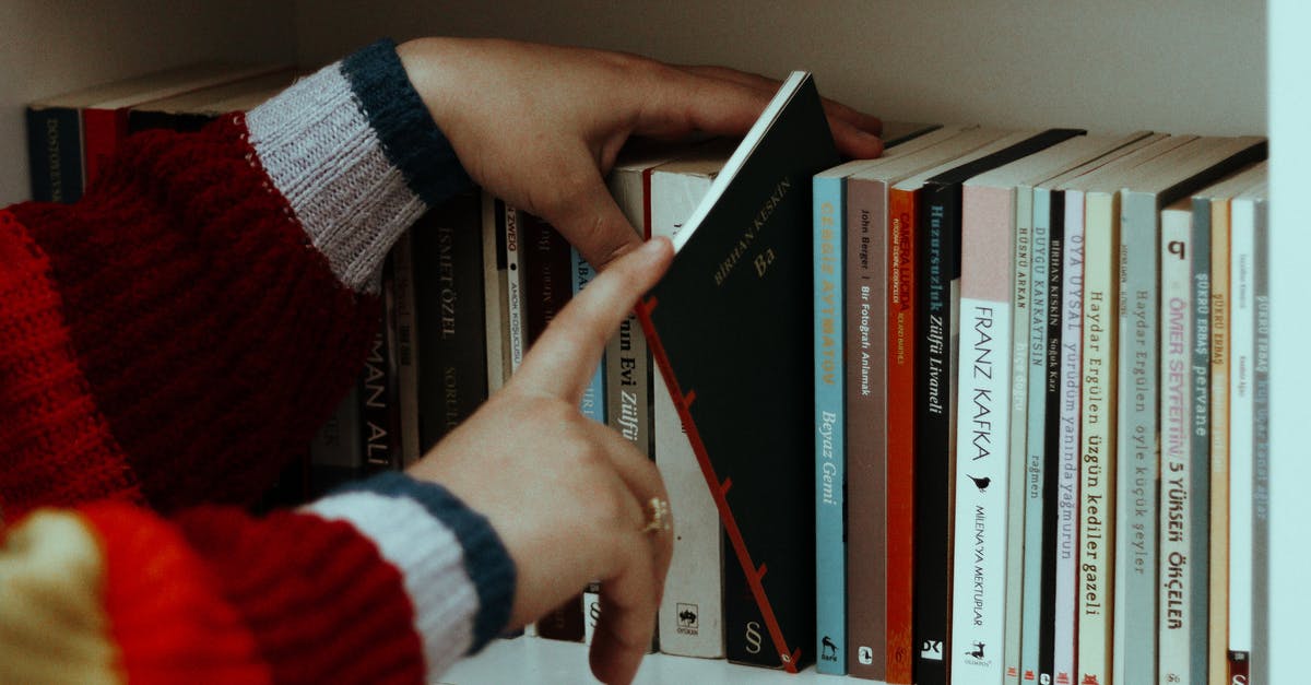 How many phones can I take to Ukraine? - Woman in striped sweater choosing books on shelf How many phones can I take to Ukraine? - Woman in striped sweater choosing books on shelf