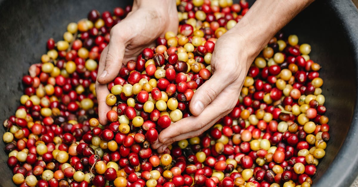 How many small fluid items are allowed in hand-luggage in European flight? - Crop man near heap of coffee beans
