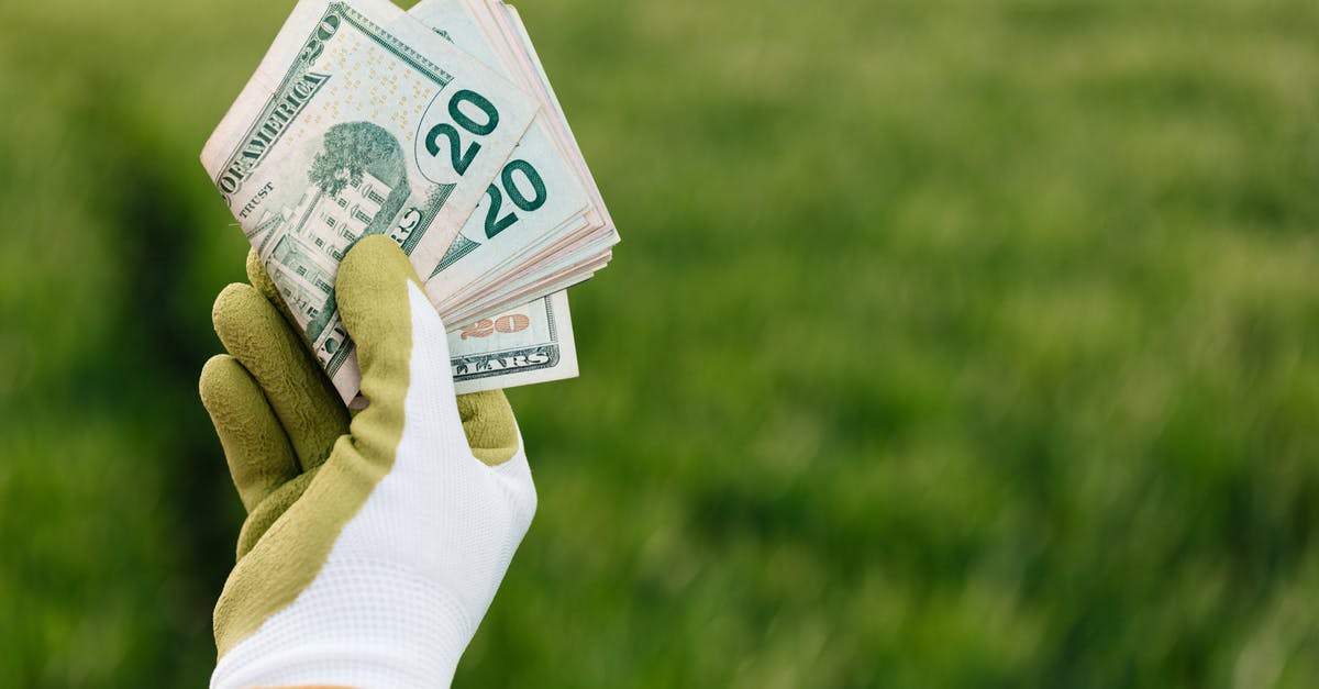How many tents per campsite in US national parks? - Crop anonymous gardener in gloves showing American paper money with number twenty and photo of building on blurred background with green field in daylight How many tents per campsite in US national parks? - Crop anonymous gardener in gloves showing American paper money with number twenty and photo of building on blurred background with green field in daylight