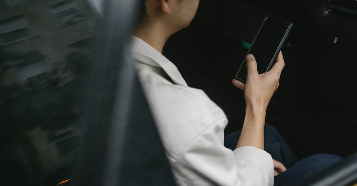 How much does a taxi from Southampton to London cost? - High angle of taxi passenger using smartphone while sitting on backseat How much does a taxi from Southampton to London cost? - High angle of taxi passenger using smartphone while sitting on backseat