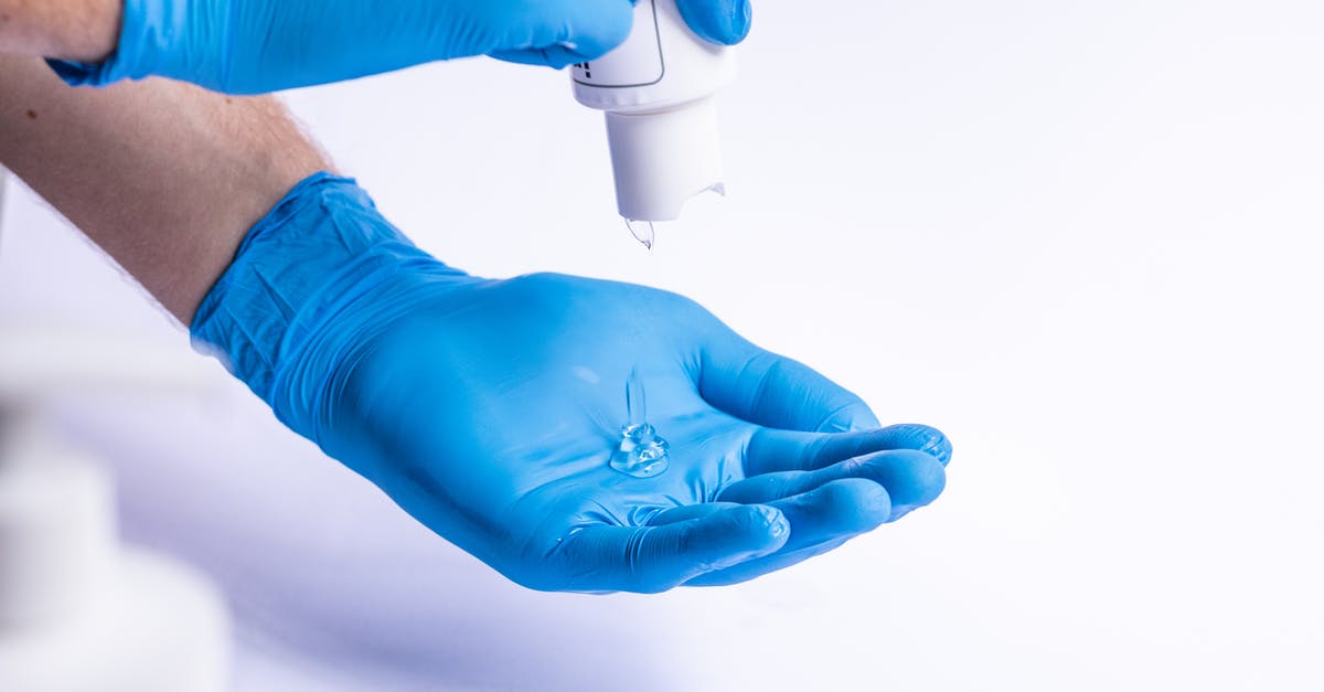 How much hand sanitizer can be taken through airport security in the EU? - Unrecognizable doctor applying antiseptic on gloves How much hand sanitizer can be taken through airport security in the EU? - Unrecognizable doctor applying antiseptic on gloves