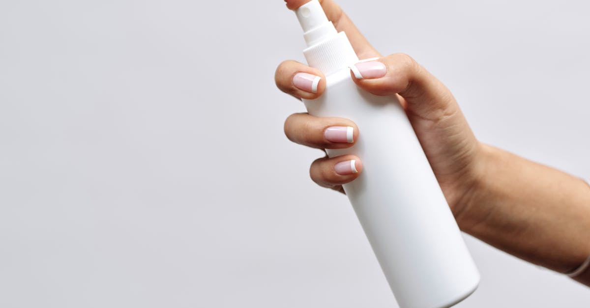 How much hand sanitizer can be taken through airport security in the EU? - Hand of a Person Holding White Plastic Bottle How much hand sanitizer can be taken through airport security in the EU? - Hand of a Person Holding White Plastic Bottle