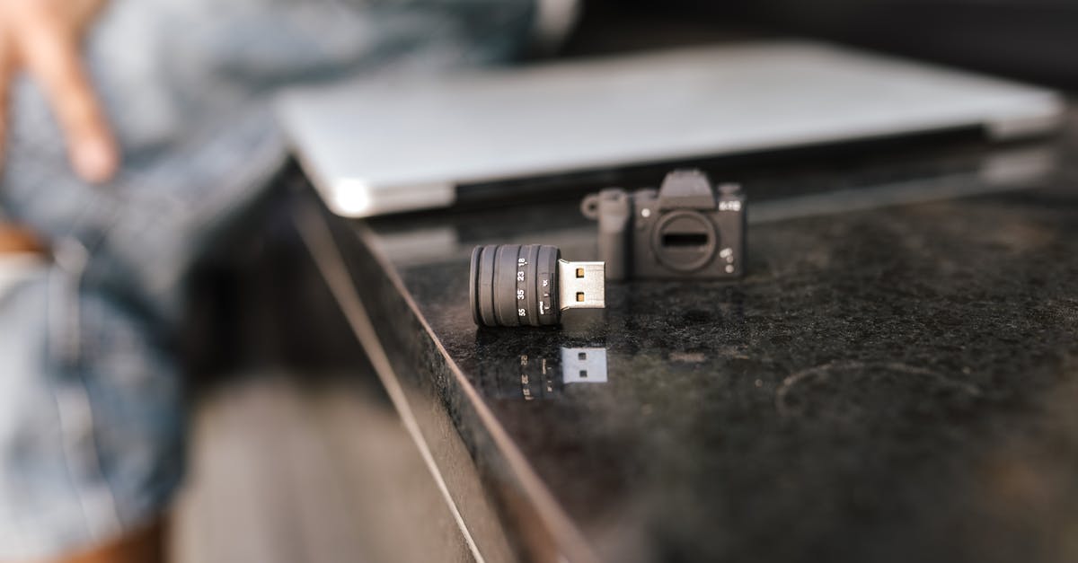 How much is a sim card at heathrow, and what network should i use [duplicate] - Crop anonymous male sitting on stone bench with modern netbook and portable contemporary USB adapter