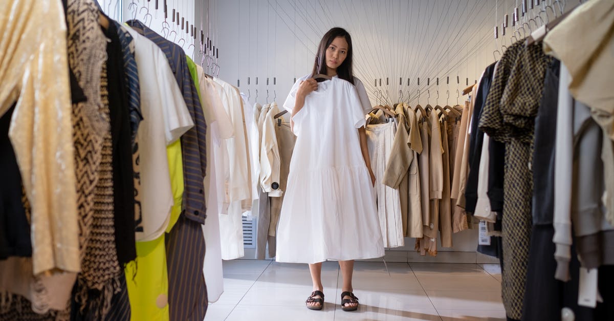 How much to store luggage at SFO for 24 hours? - Woman in White Long Sleeve Dress Standing on White Floor Tiles