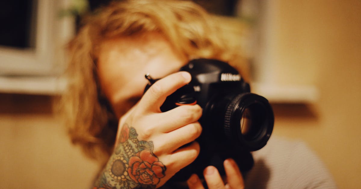 How often do cameras get stolen while someone is using them in SE Asia? - A Person with Rose Tattoo Holding Black  Camera