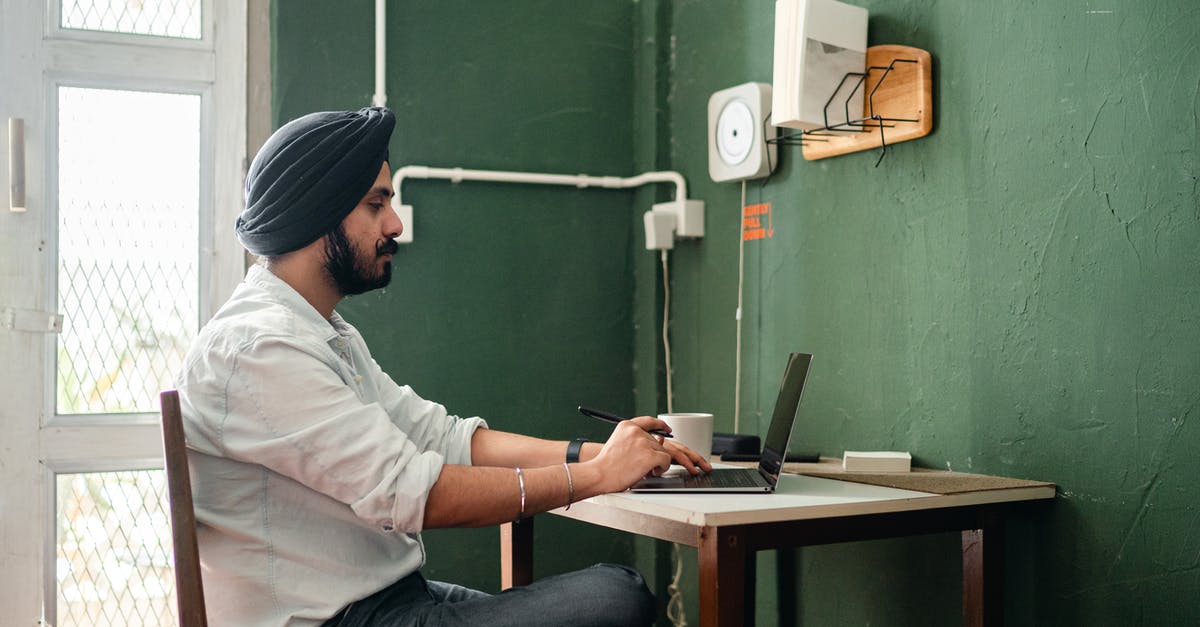 How probable is it to get a short stay visa for France as an Indian inside 3-4 business days? [closed] - Side view of focused adult ethnic man in casual clothes and hat using netbook while sitting at table with pen