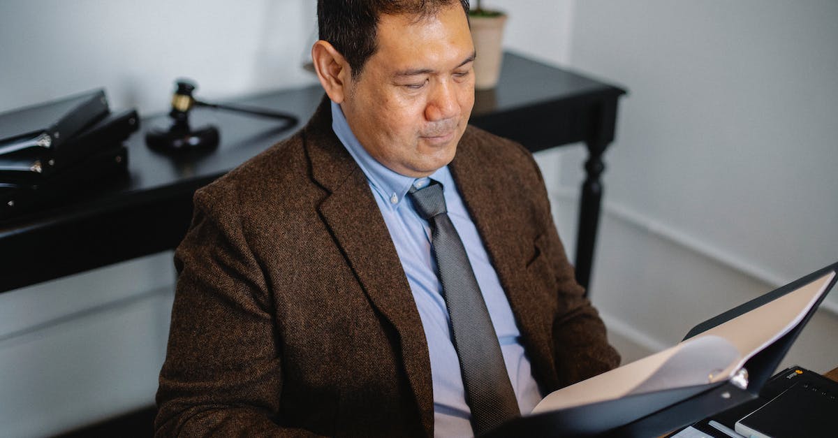 How reliable are hotels' information on their websites? - Pensive Asian lawyer examining report in office How reliable are hotels' information on their websites? - Pensive Asian lawyer examining report in office