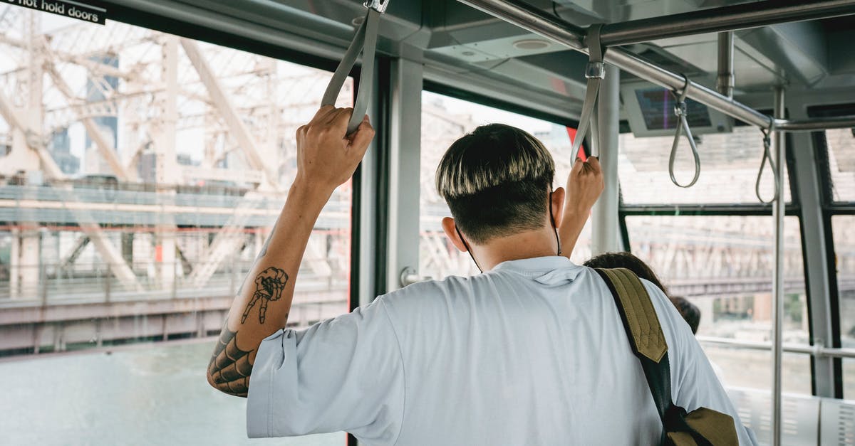 How safe are cable cars? - Back view of anonymous male with modern haircut and backpack near partner in cable cabin during trip over river How safe are cable cars? - Back view of anonymous male with modern haircut and backpack near partner in cable cabin during trip over river