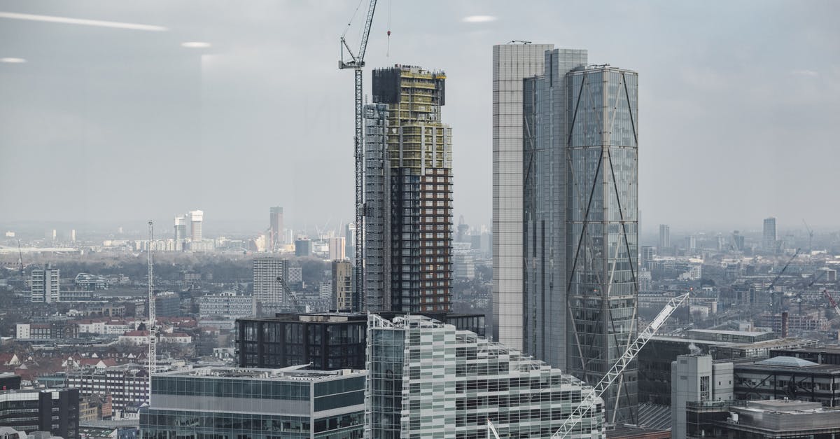 How should I answer financial questions for UK Standard Visitor visa applications for travel as a family? [closed] - Complex of modern multistory buildings and commercial skyscrapers with tower cranes under cloudy sky in London