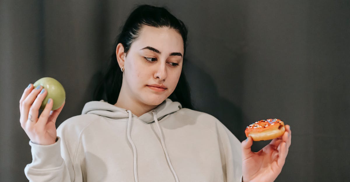 How should I choose the best option for a London apartment rental? [closed] - Thoughtful woman choosing between green apple and sweet donut