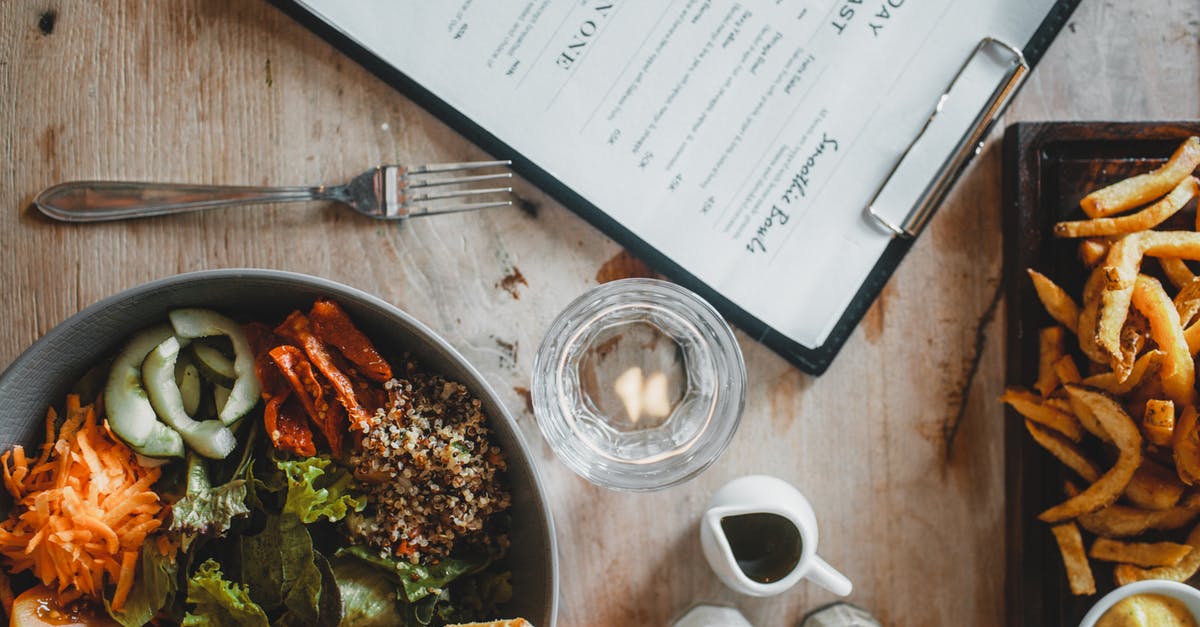 How should I tip if the food is good but the service from the waiter/waitress is terrible in the USA? - Salad bowl and french fries served on table in cafe