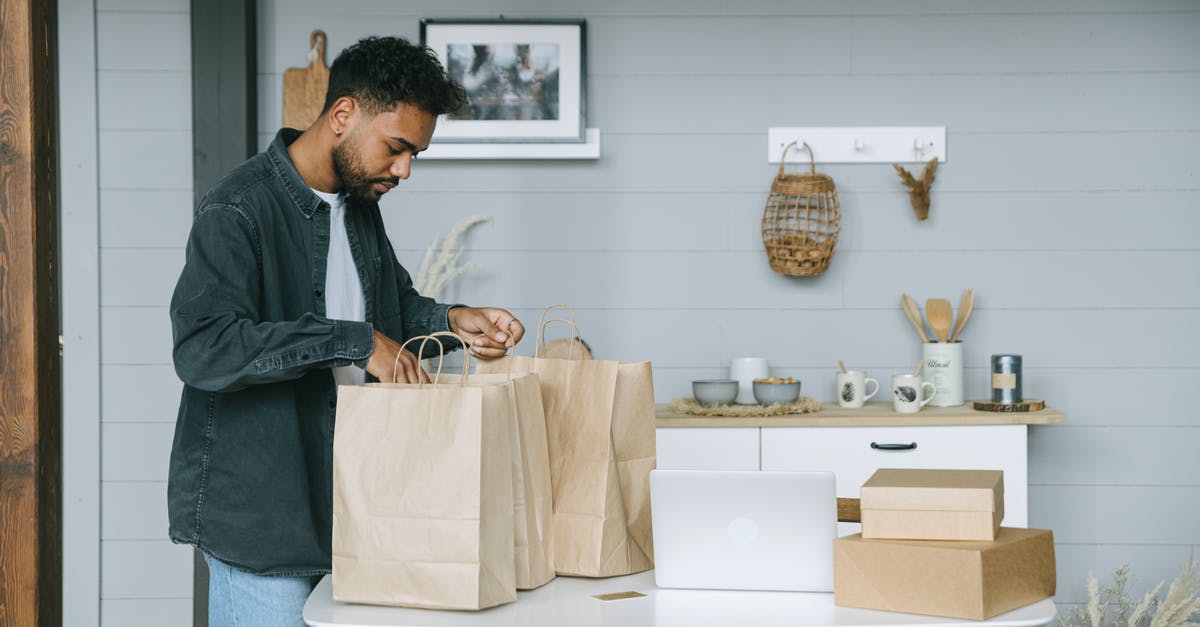 How should one prepare for a business trip to Manila? - Man in Gray Dress Shirt and Blue Denim Jeans Standing Beside White Table How should one prepare for a business trip to Manila? - Man in Gray Dress Shirt and Blue Denim Jeans Standing Beside White Table