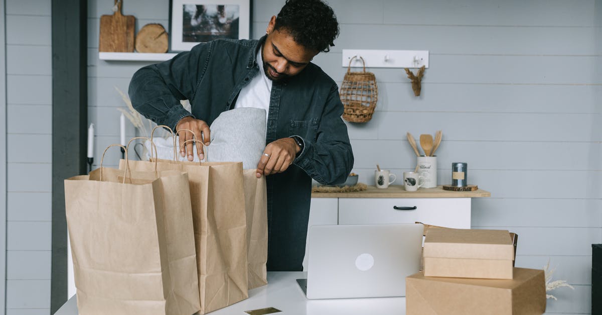 How should one prepare for a business trip to Manila? - Man in Gray Dress Shirt Holding White Textile How should one prepare for a business trip to Manila? - Man in Gray Dress Shirt Holding White Textile