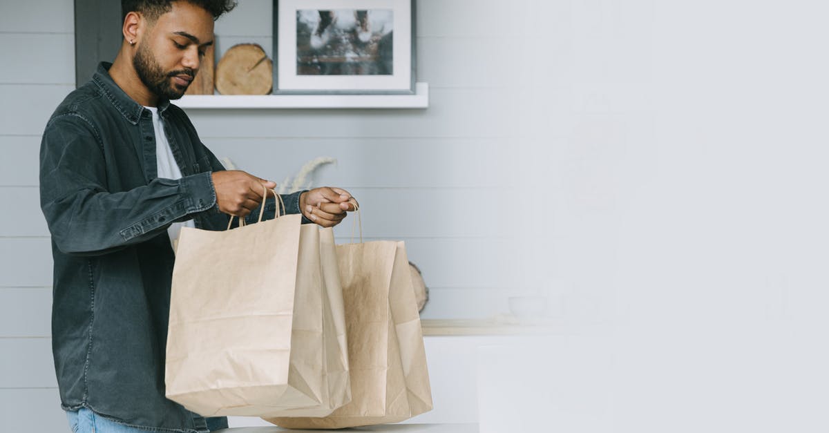 How should one prepare for a business trip to Manila? - Man in Black and White Plaid Dress Shirt Holding White Textile How should one prepare for a business trip to Manila? - Man in Black and White Plaid Dress Shirt Holding White Textile