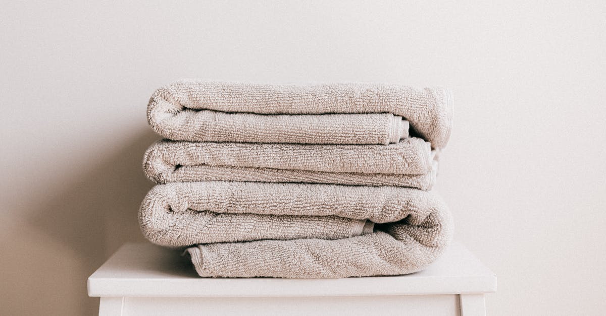 How strict is Air Berlin about dimensions of personal items such as soft backpacks? - Stack of soft clean light beige folded towels placed on white minimalist stool against beige wall in daylight