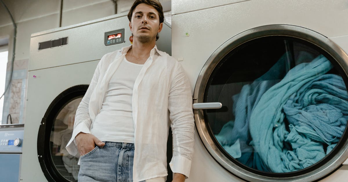 How to avoid to get your clothes to disappear in Indonesian laundry services? - A Low Angle Shot of a Man in White Long Sleeves Leaning on a Washing Machine How to avoid to get your clothes to disappear in Indonesian laundry services? - A Low Angle Shot of a Man in White Long Sleeves Leaning on a Washing Machine