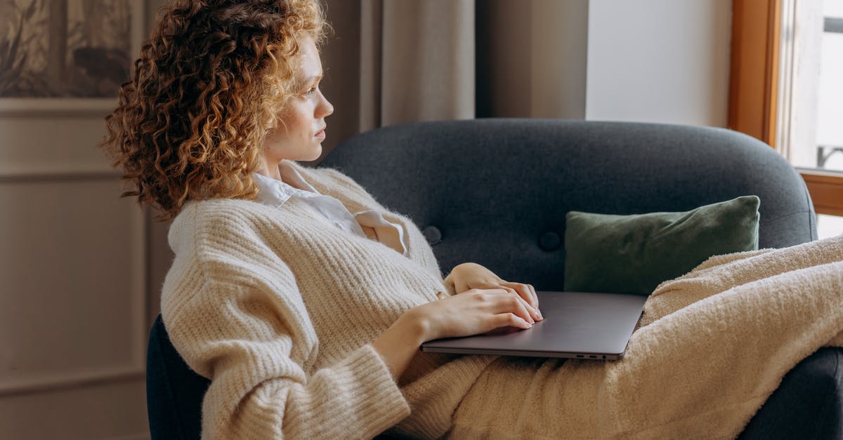 How to book an early morning taxi to Rome Airport? - Woman in White Sweater Sitting on Gray Sofa Using Macbook How to book an early morning taxi to Rome Airport? - Woman in White Sweater Sitting on Gray Sofa Using Macbook
