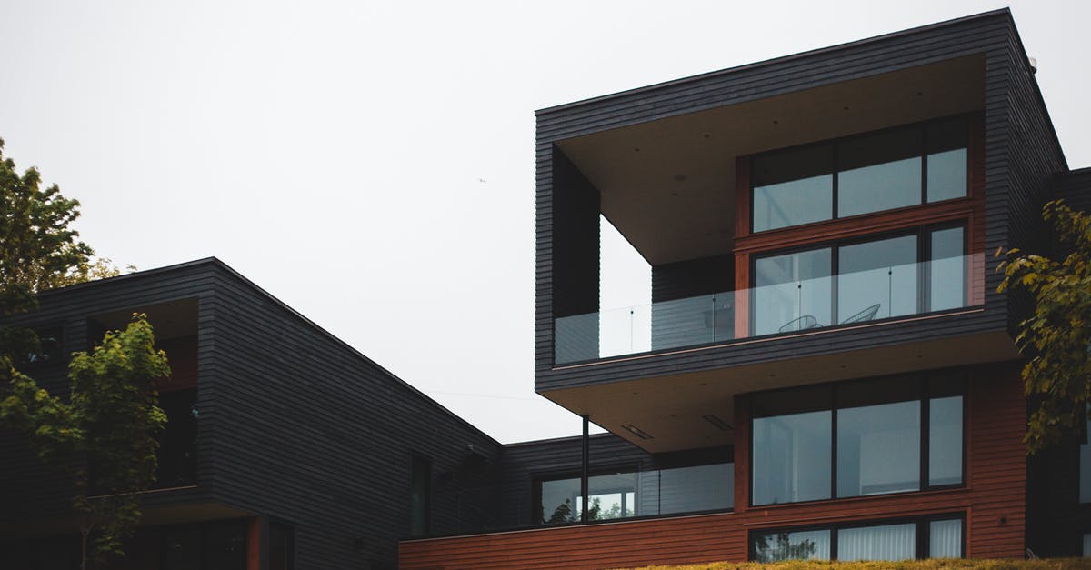 How to call 911 for my home area when overseas? [duplicate] - From below of contemporary geometric building with big windows and stylish design of balcony on green grass with trees