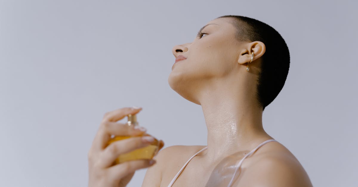 How to carry cologne bottles in hand luggage and prevent losses? - Woman Spraying Perfume on Her Neck How to carry cologne bottles in hand luggage and prevent losses? - Woman Spraying Perfume on Her Neck