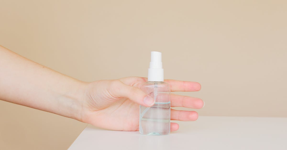 How to carry cologne bottles in hand luggage and prevent losses? - Crop woman taking bottle of antiseptic from table How to carry cologne bottles in hand luggage and prevent losses? - Crop woman taking bottle of antiseptic from table
